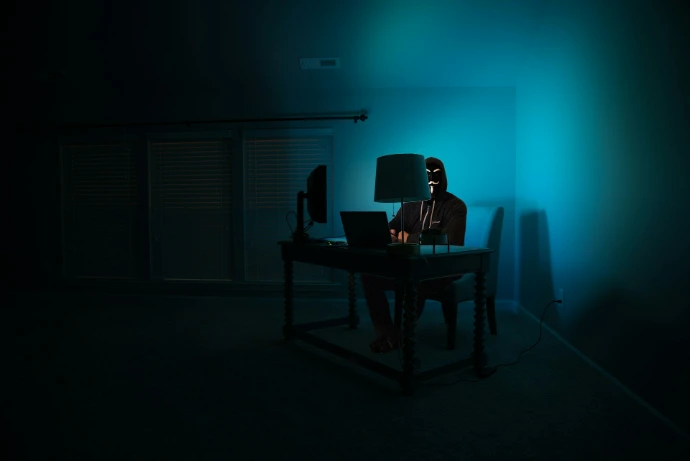 man sitting facing laptop