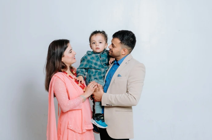 A man and woman holding a small child